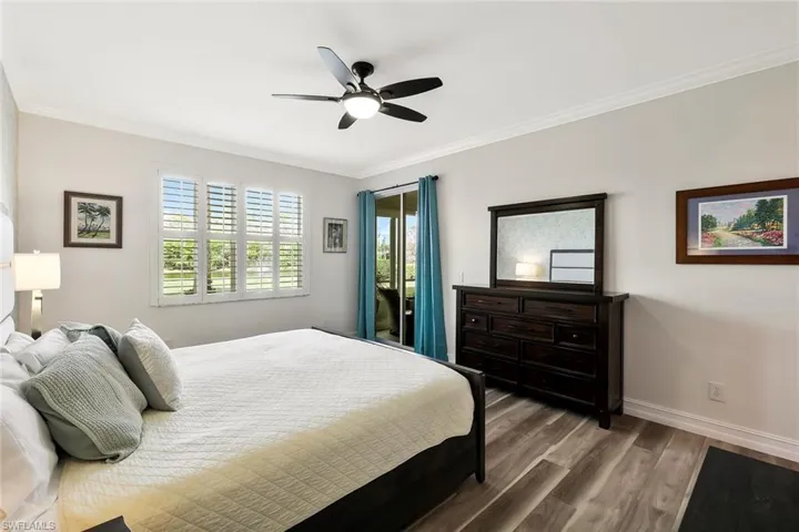 Bedroom featuring dark wood finished floors, crown molding, a ceiling fan, and access to exterior