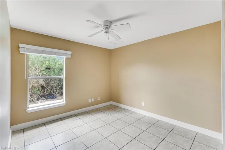 Spare room featuring a ceiling fan and light tile patterned floors