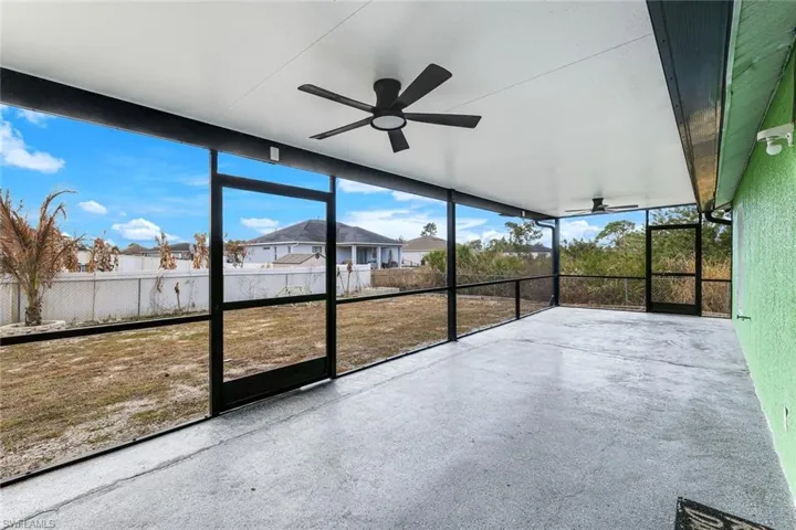 Unfurnished sunroom with ceiling fan and a residential view