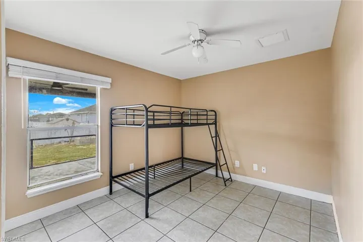 Unfurnished bedroom featuring ceiling fan and light tile patterned flooring