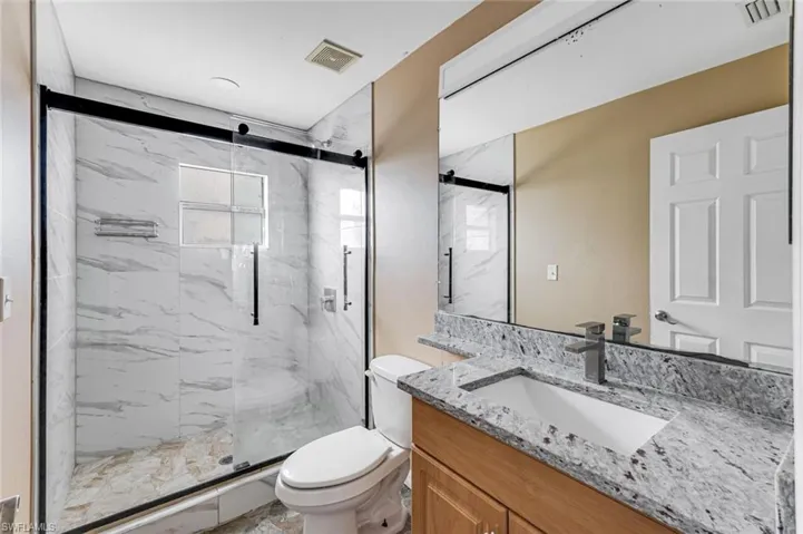 Full bathroom with a marble finish shower and vanity
