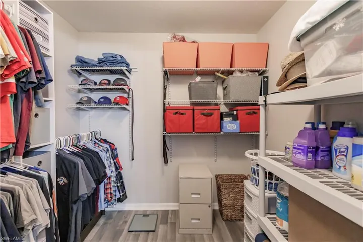 Walk in closet with hardwood / wood-style floors