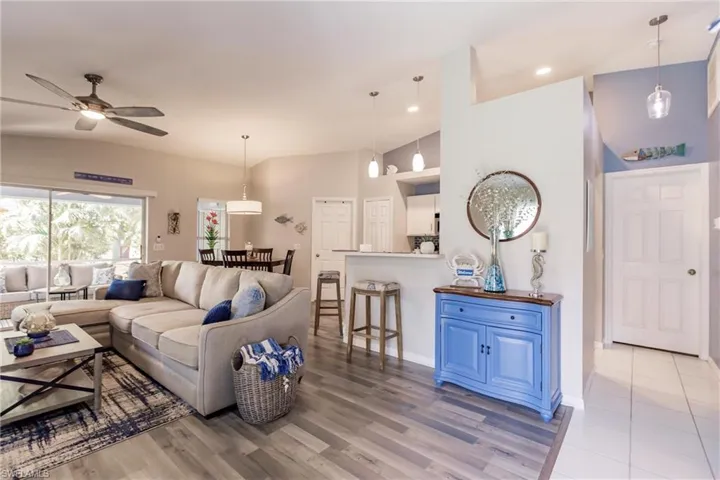 Living room featuring ceiling fan, hardwood / wood-style flooring, and high vaulted ceiling