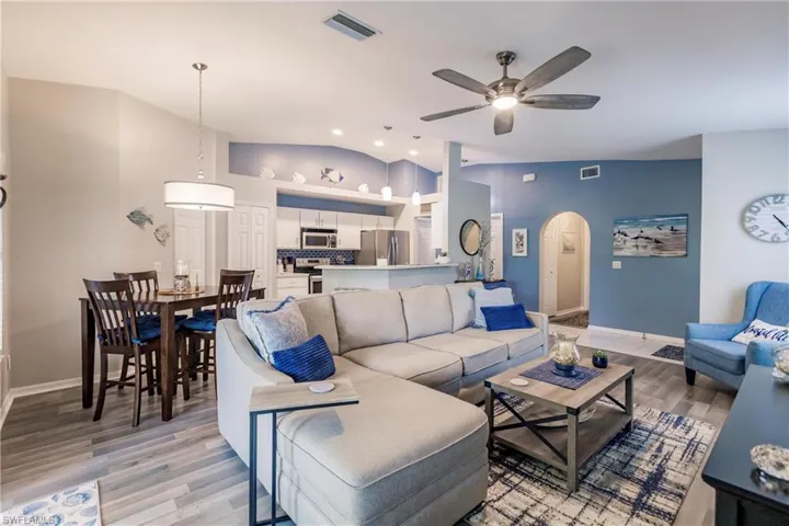 Living room featuring light hardwood / wood-style floors, high vaulted ceiling, and ceiling fan