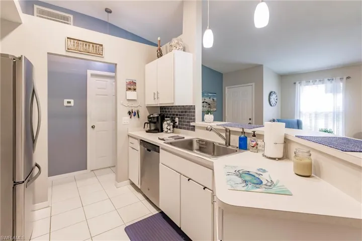 Kitchen featuring sink, pendant lighting, stainless steel appliances, and white cabinets