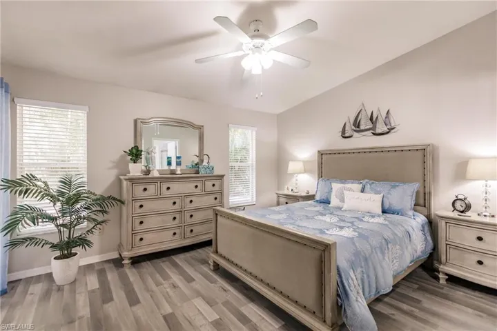 Bedroom featuring wood-type flooring, multiple windows, and ceiling fan