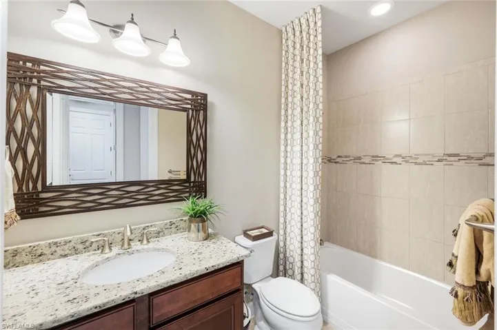 Full bath featuring vanity and shower / tub combo with curtain