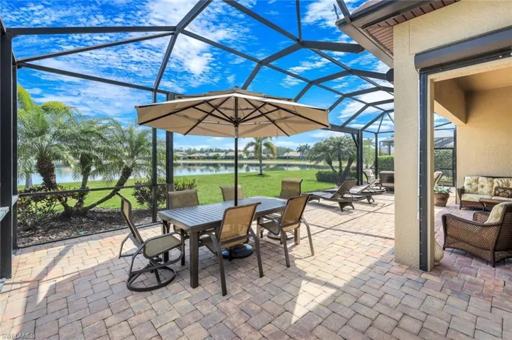View of patio / terrace with a sunroom, outdoor lounge area, glass enclosure, and a water view