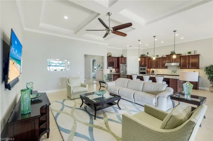 Living room with coffered ceiling, crown molding, ceiling fan, and recessed lighting
