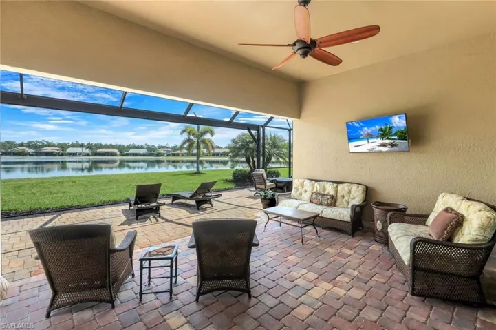 View of patio featuring a lanai, a sunroom, ceiling fan, and outdoor seating