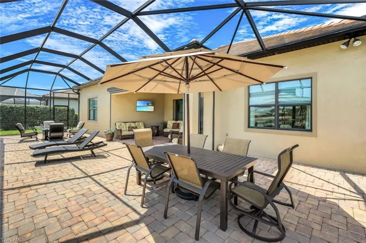 View of patio featuring a sunroom, outdoor dining area, and a lanai