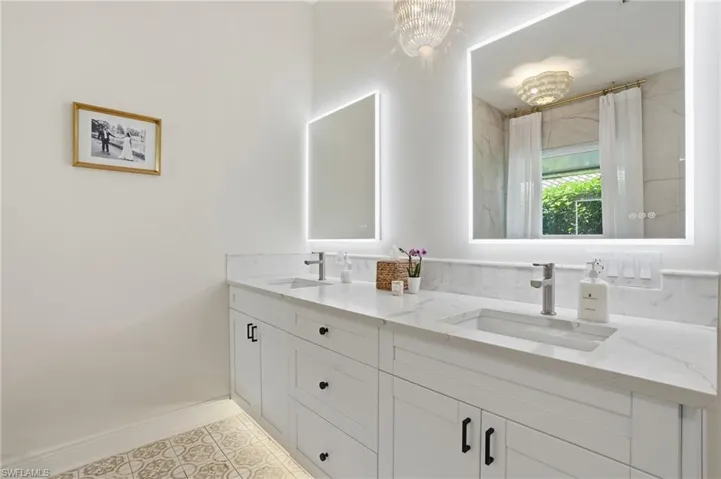 Dual vanity featuring white shaker cabinetry, integrated rectangular sinks, and white stone countertops