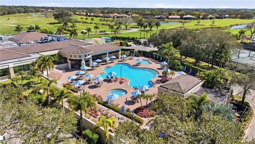 Resort-style pool area featuring a freeform swimming pool, integrated spa, and extensive paver decking