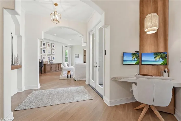 Built-in desk area featuring a textured wood slat accent wall and a woven light fixture