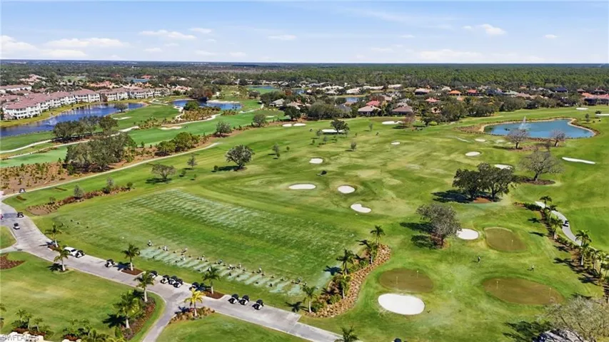 Expansive golf course setting featuring multiple sand traps, manicured greens, and mature trees