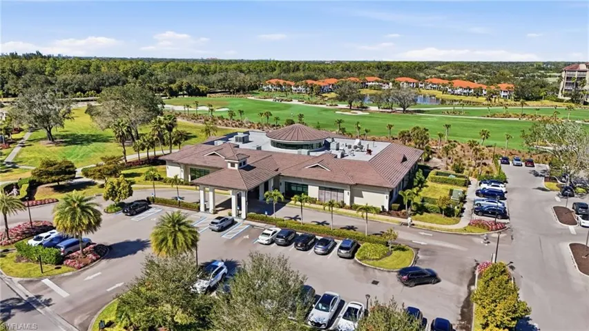 Expansive community clubhouse featuring a covered entryway, a prominent central rotunda, and ample parking