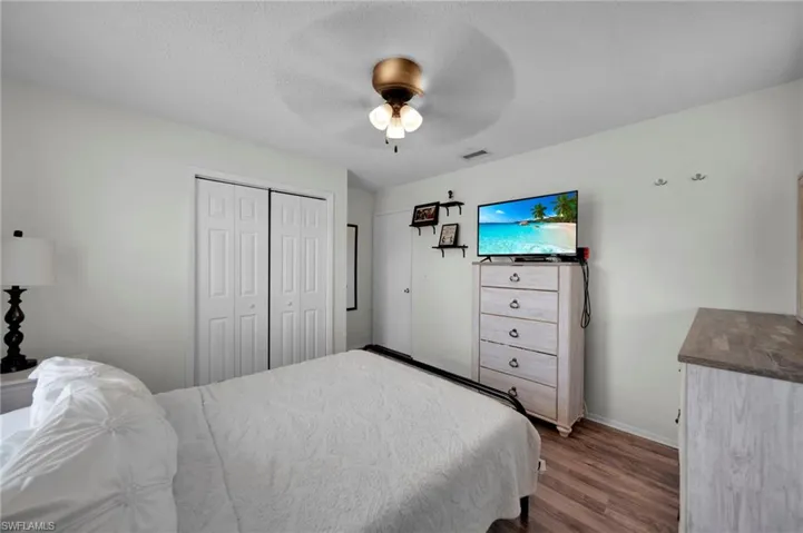 Bedroom 1 featuring a textured ceiling, wood finished floors, and ceiling fan