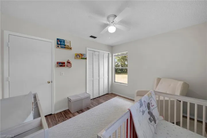 Bedroom 2 with a closet, baseboards, wood finished floors, and a textured ceiling