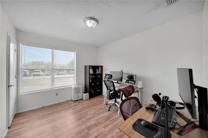Home office/ Bedroom/ storage room 3-with Vinyl Wood floors, baseboards, visible vents, and a textured ceiling