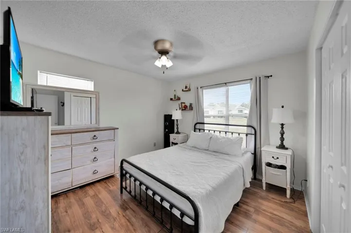 Bedroom 1 featuring a closet, a ceiling fan, visible vents, wood finished floors, and baseboards