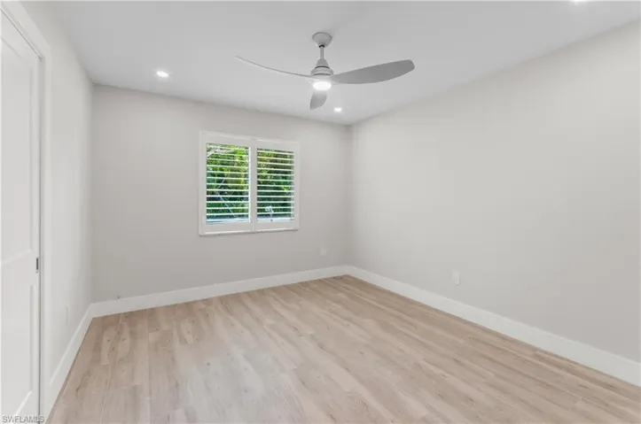 Empty room featuring light wood finished floors, a ceiling fan, and recessed lighting