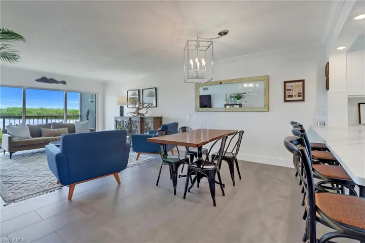 Dining room featuring ornamental molding, light tile patterned floors, and an inviting chandelier