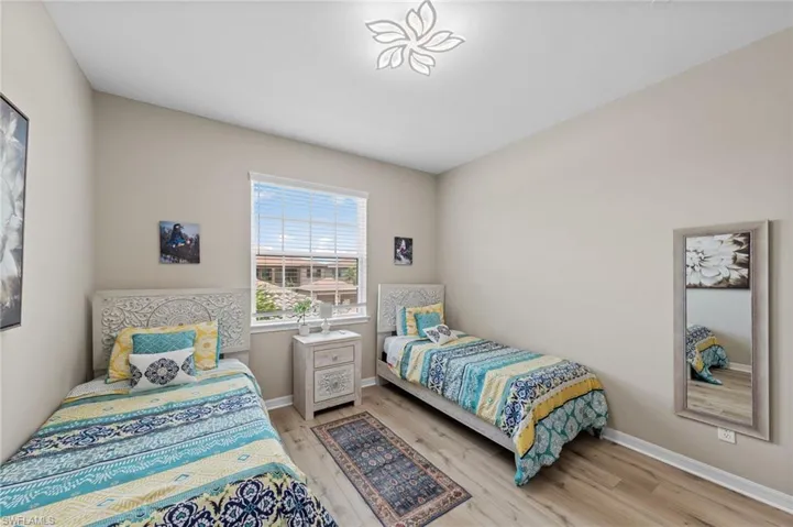 Bright room featuring wood-finish flooring and a single window with horizontal blinds