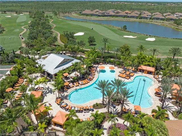 Resort-style pool area featuring a large swimming pool with integrated lap lanes, surrounding lounge seating, and multiple shaded cabanas
