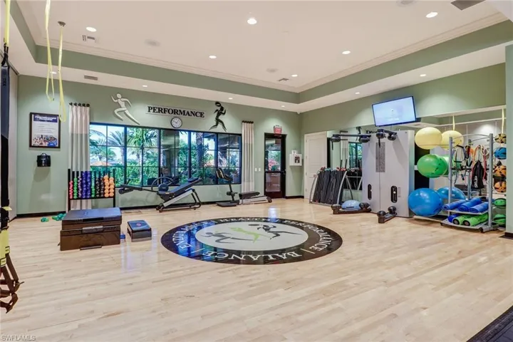 Dedicated fitness space featuring light wood-finish flooring with a central circular graphic