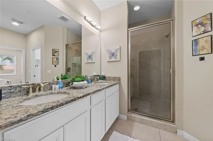 Bathroom featuring a dual vanity with granite countertop, undermount sinks, and brushed nickel faucets