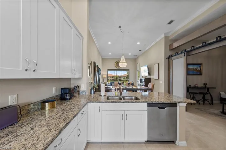 Kitchen featuring light-finish cabinetry, granite countertops, and a built-in stainless steel dishwasher