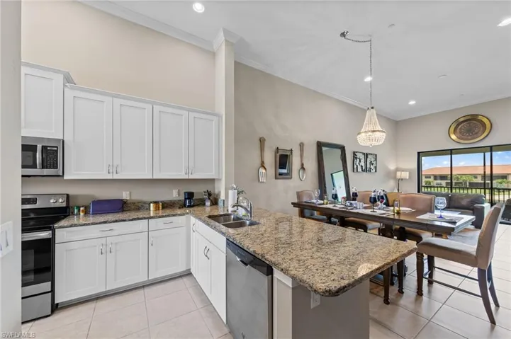 Contemporary kitchen featuring white cabinetry, stainless steel appliances, and granite countertops
