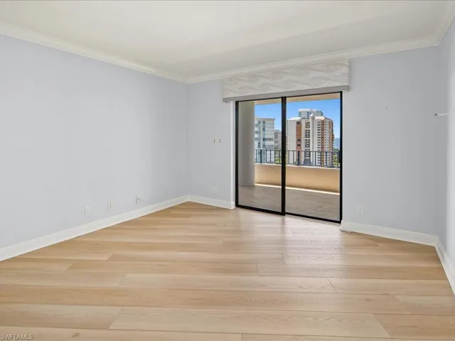 Empty room with light wood-type flooring and ornamental molding