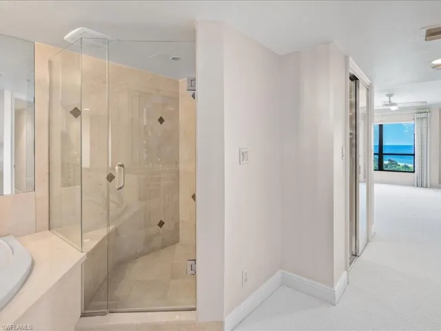 Bathroom featuring ceiling fan and separate shower and tub