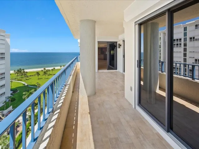 Balcony featuring a water view and a view of the beach
