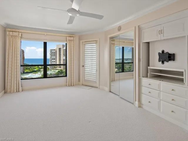 Unfurnished bedroom featuring ornamental molding, multiple windows, and light colored carpet