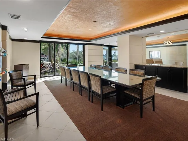 Dining area with light tile patterned flooring and a raised ceiling