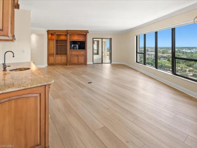 Unfurnished living room featuring ornamental molding, light hardwood / wood-style floors, and sink