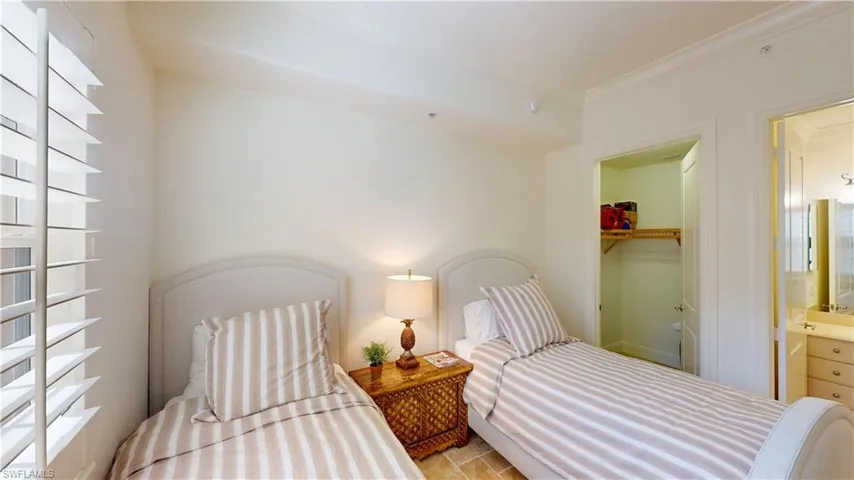 Bedroom with a walk in closet, ornamental molding, and a closet