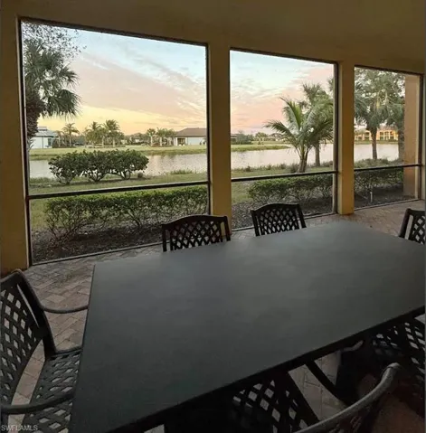 Sunroom featuring a water view and outdoor dining space