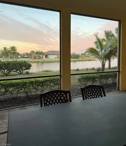 Sunroom featuring outdoor dining space and a water view