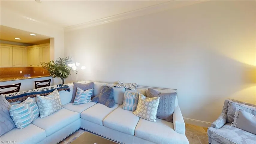 Living room featuring crown molding and light tile patterned flooring