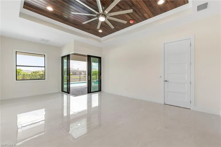 Empty room featuring a raised ceiling, wood ceiling, a ceiling fan, recessed lighting, and light marble finish floors