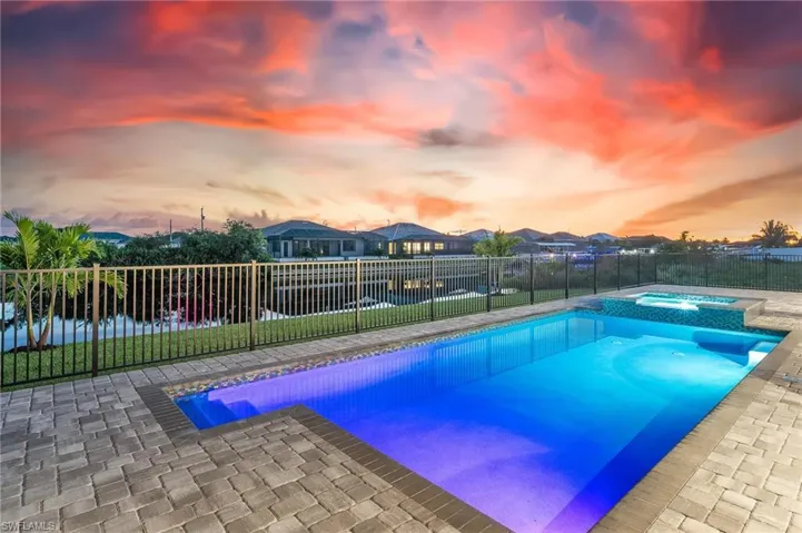 View of swimming pool with a patio area, a fenced backyard, a pool with connected hot tub, and a residential view
