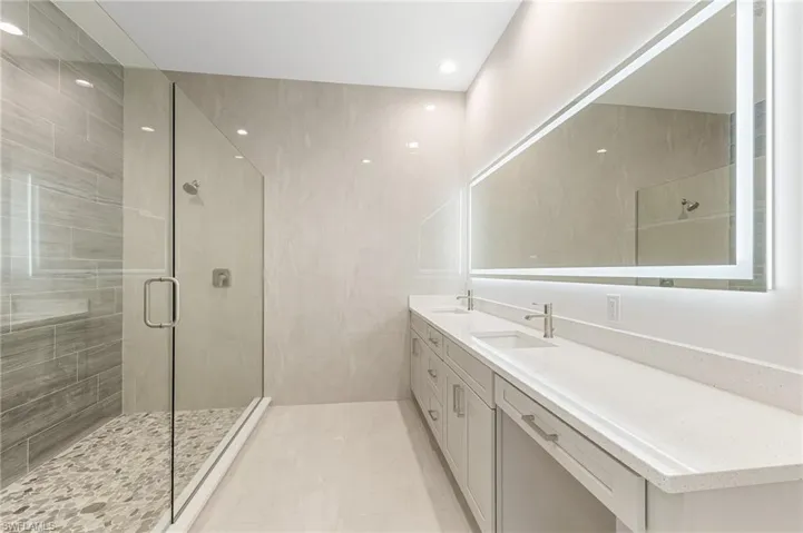 Junior Suite Bathroom featuring double vanity, a shower stall, and recessed lighting