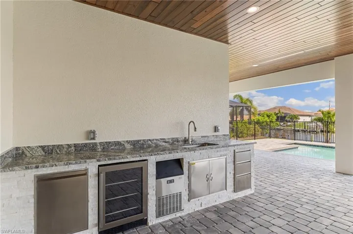 View of patio with exterior kitchen and beverage cooler