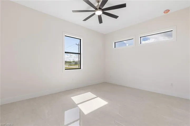 Unfurnished room featuring healthy amount of natural light and ceiling fan