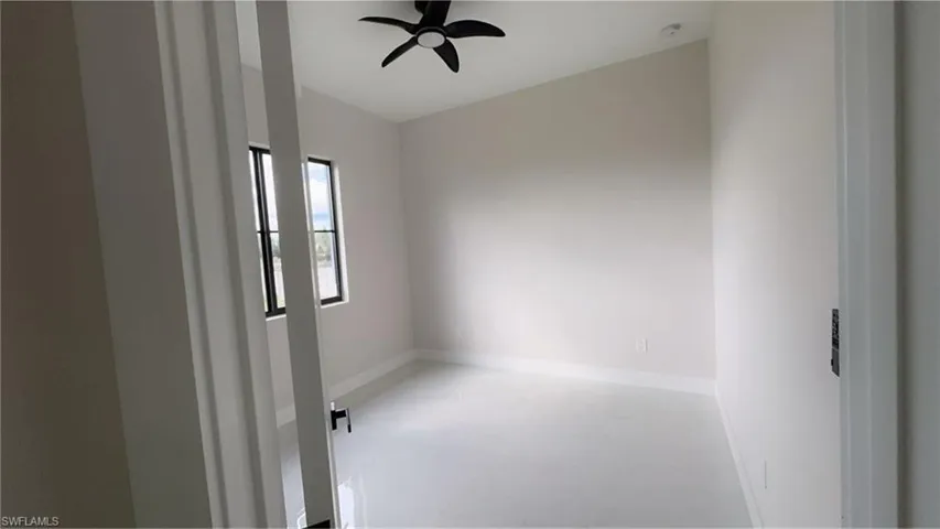 Empty room with concrete flooring and a ceiling fan