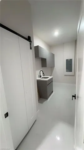 Laundry area with a barn door and electric panel