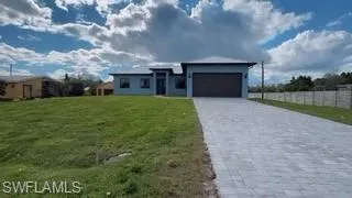View of front of property with decorative driveway and an attached garage